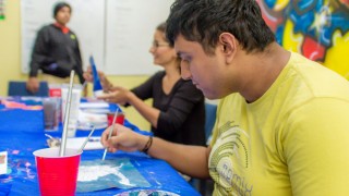 young adult with autism finishes off painting