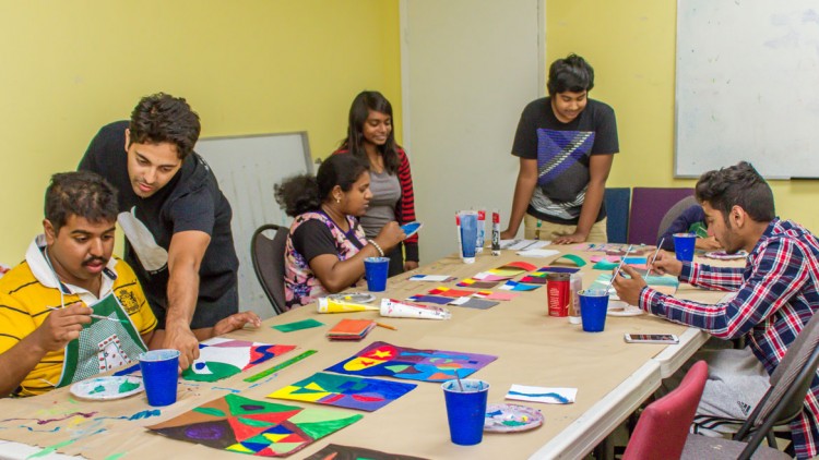 instructors helping young adults with autism in new painting program